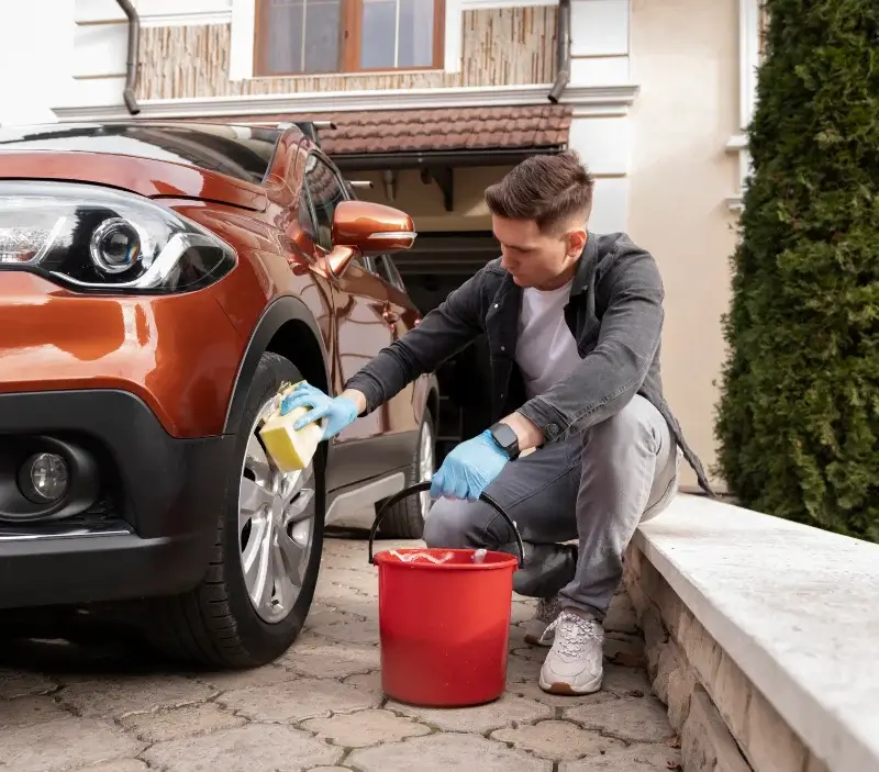 Lavage auto à domicile Morteaux-Coulibœuf : professionnel intervenant sur un véhicule